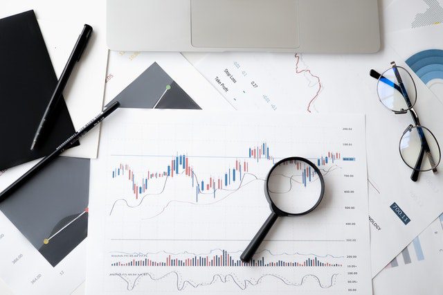 Financial charts with magnifying glass and glasses